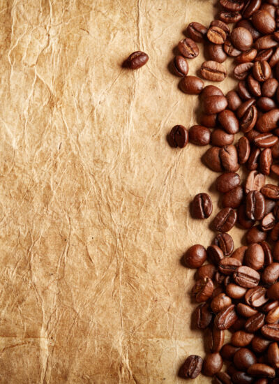 roasted coffee beans on antique paper with blank copy space as background