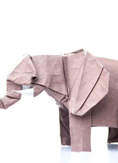 Brown elephant origami figurine. Paper design of animals. Difficult and beautiful art made by child.